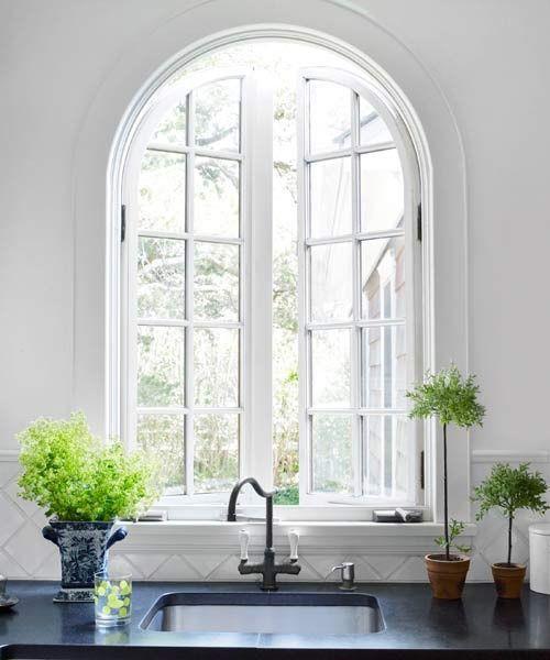 Ημικυκλικά παράθυρα τοξωτά περάσματα δωματίων ένα φωτεινό και πολύ ελκυστικό νεροχύτη κουζίνας φυτά θερμοκήπιο