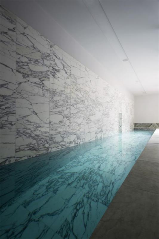 Εσωτερική πισίνα στο σπίτι Καθαρός μινιμαλισμός στο σχεδιασμό μαρμάρινων πάνελ στον τοίχο σε γκρι χρώμα