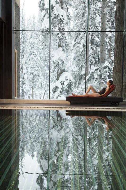 Εσωτερική πισίνα στο σπίτι μαγευτική θέα γυάλινο τοίχο χειμερινό τοπίο μέσα σε ζεστή ξαπλώστρα πισίνας χαλαρώστε