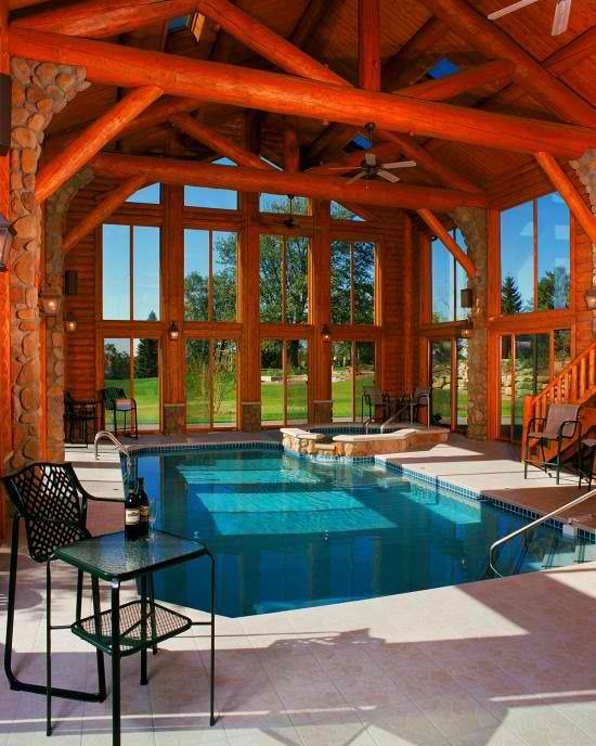 Εσωτερική πισίνα στο σπίτι στο ξεχωριστό περίπτερο με πολλά ξύλινα πέτρινα τοιχώματα ζεστή ατμόσφαιρα