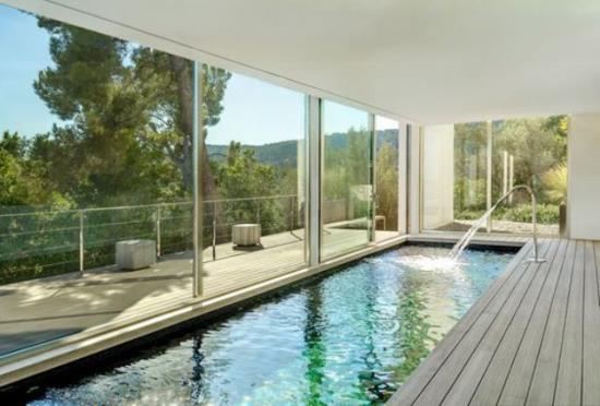 Εσωτερική πισίνα στο σπίτι επιμήκη μορφή γυάλινο παράθυρο όμορφη θέα στον κήπο