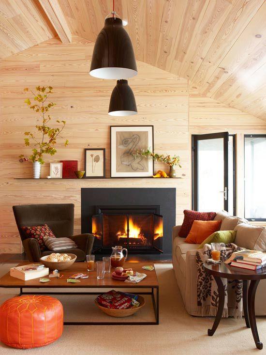 Φθινοπωρινή διακόσμηση στο σαλόνι, ξύλινη οροφή, αναμμένη φωτιά στο τζάκι, ζεστά χρώματα τριγύρω, πολύ άνετα και ζεστά