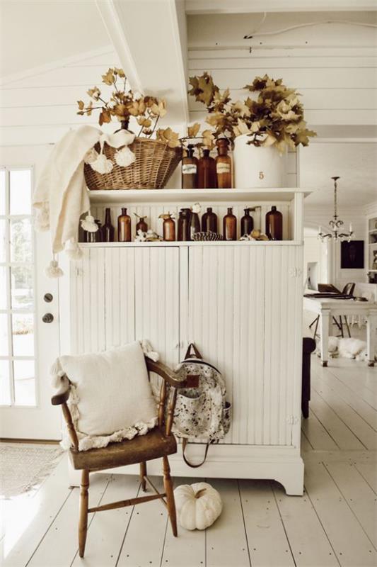 Φθινοπωρινή διακόσμηση στο ντουλάπι του σαλονιού σε vintage στυλ φθινοπωρινή διακόσμηση γυαλιών βάζο ψάθινο καλάθι με πολύχρωμα κλαδιά