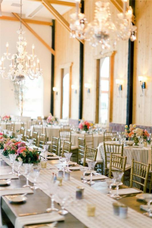 Γαμήλια τραπέζια λουλούδια φωτίζουν μεγάλο γυαλιστερό μεγάλο τραπέζι
