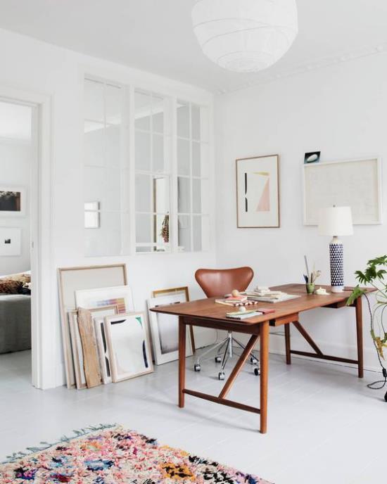 Γραφείο σπιτιού σε ουδέτερα χρώματα σοκολάτα καφέ δερμάτινη καρέκλα κομψό ξύλινο επιτραπέζιο φωτιστικό πολύχρωμο χαλί δαπέδου με κρόσσια