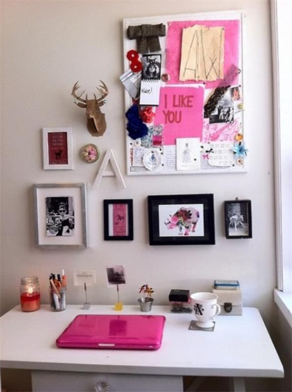 Το γραφείο του σπιτιού με μια θηλυκή εμφάνιση, εικόνες και σχέδια κρέμονται στον τοίχο ως έμπνευση