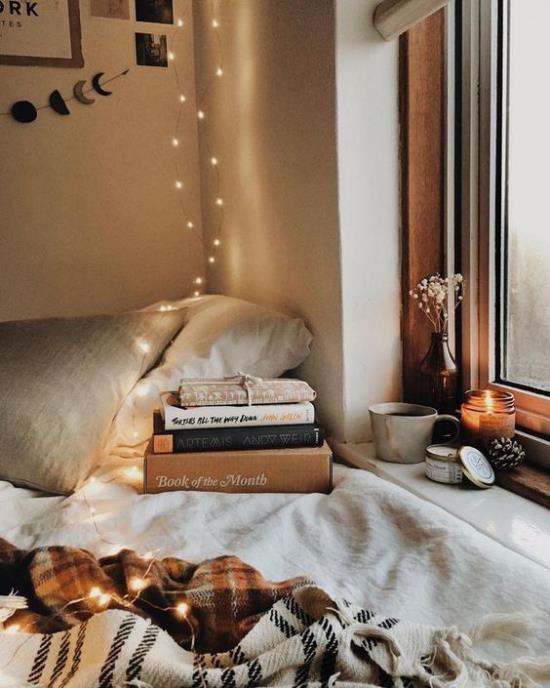 Αίσθηση Hygge στη χριστουγεννιάτικη ζεστή γωνιά στο κρεβάτι απαλές υφές που διαβάζουν βιβλία