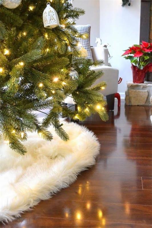 Αίσθηση Hygge στο χριστουγεννιάτικο έλατο λευκή faux γούνα poinsettia στο παρασκήνιο