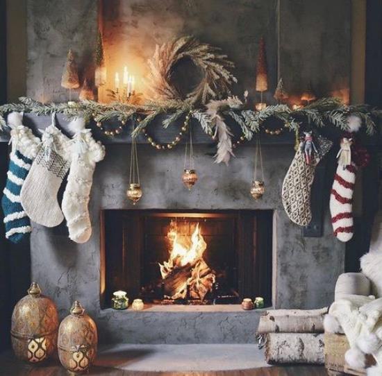 Η αίσθηση Hygge για τα Χριστούγεννα διακοσμεί το τζάκι αυτο-πλεκτές κάλτσες κεριά ξύλινα δώρα της φύσης