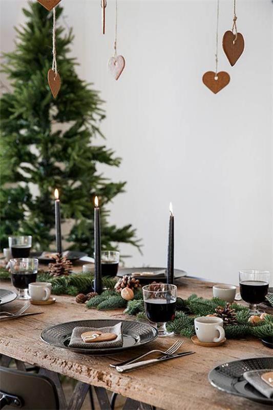 Αίσθηση Hygge στο χριστουγεννιάτικο εορταστικό τραπέζι από ξύλινα κεριά από έλατο κλαδιά έλατου δίπλα