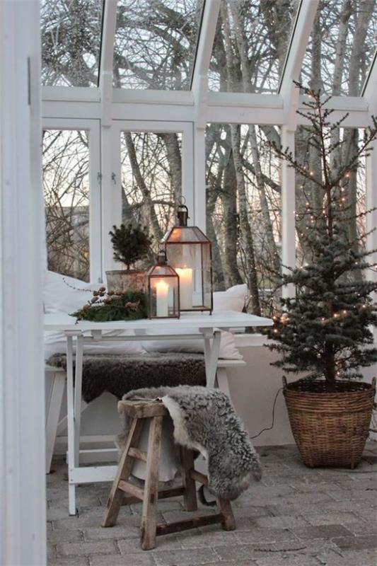 Αίσθηση Hygge τα Χριστούγεννα φωτεινή απλή ατμόσφαιρα τυπικά σκανδιναβικά φανάρια λευκά κεριά ανάβει ψεύτικη γούνα