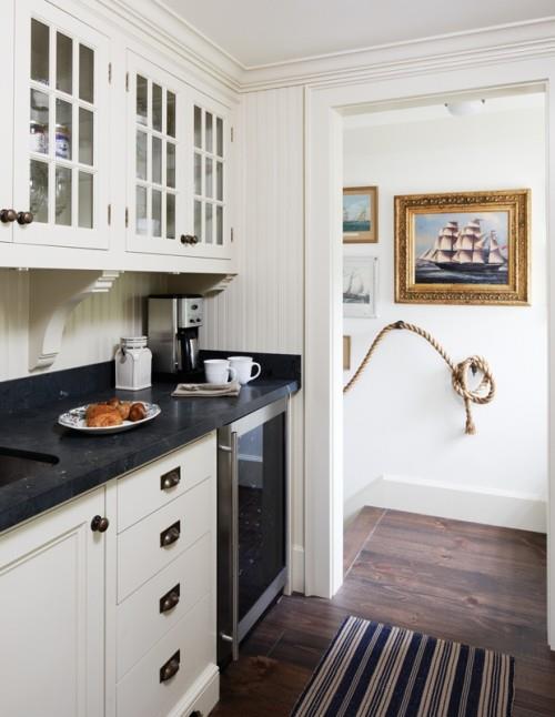 Κουζίνα λευκά ντουλάπια μαύρο πάγκο ξύλινο πάτωμα