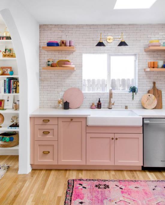 Ρετρό στυλ ντουλάπια κουζίνας σε σκονισμένο ροζ τοίχο από τούβλα σε ασβεστωμένες μοκέτες σε ροζ αποχρώσεις