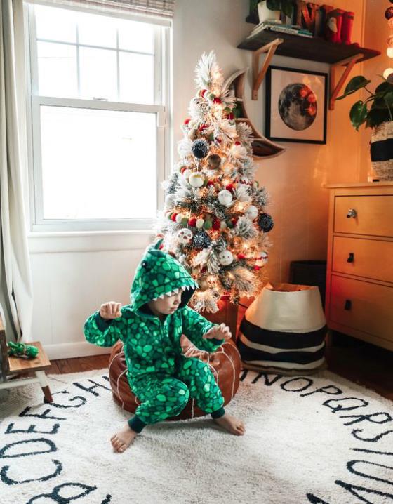 Διακοσμήστε το παιδικό δωμάτιο για Χριστουγεννιάτικο παιχνίδι παράδεισος όμορφα διακοσμημένο χριστουγεννιάτικο δέντρο μικρό αγόρι μπροστά στο χαλί