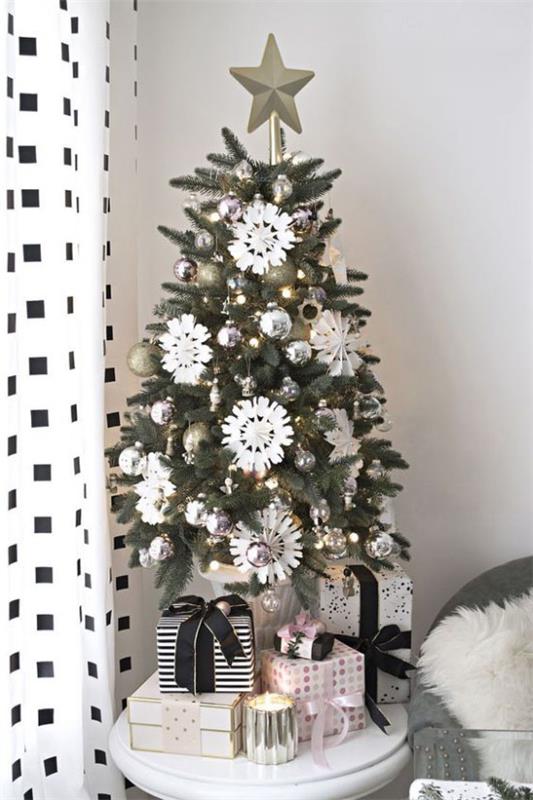 Μικρό χριστουγεννιάτικο δέντρο στολίζει βιτρίνα Χριστουγεννιάτικη διακόσμηση σε ασπρόμαυρες νιφάδες χιονιού με αστέρια από κάτω