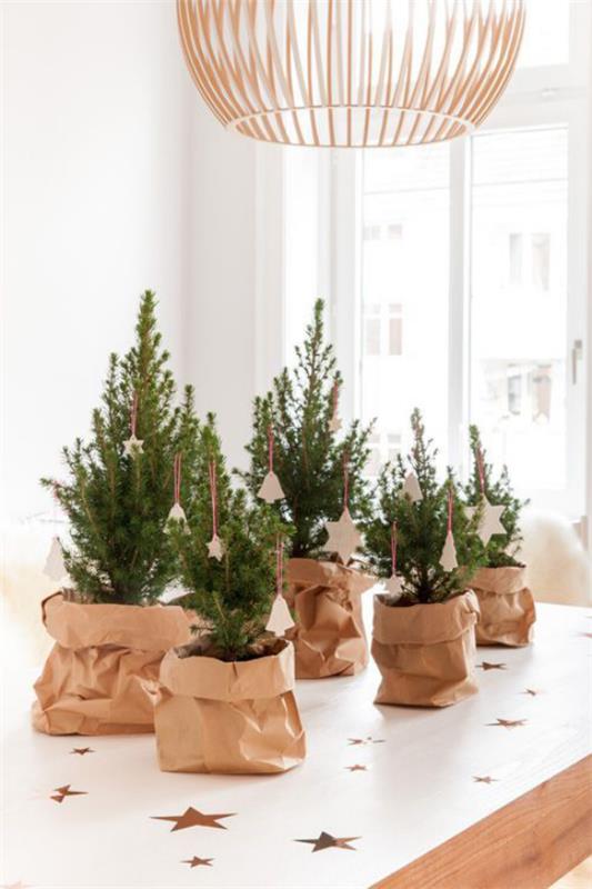Μικρές διακοσμήσεις χριστουγεννιάτικων δέντρων αναδεικνύουν μερικά χριστουγεννιάτικα δέντρα σε χάρτινα τσουβάλια στο τραπέζι της κουζίνας