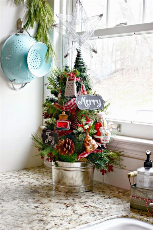 Μικρό χριστουγεννιάτικο δέντρο στολίζει οθόνη μικρά σκεύη κουζίνας στο δέντρο σε μια γωνία στον πάγκο της κουζίνας