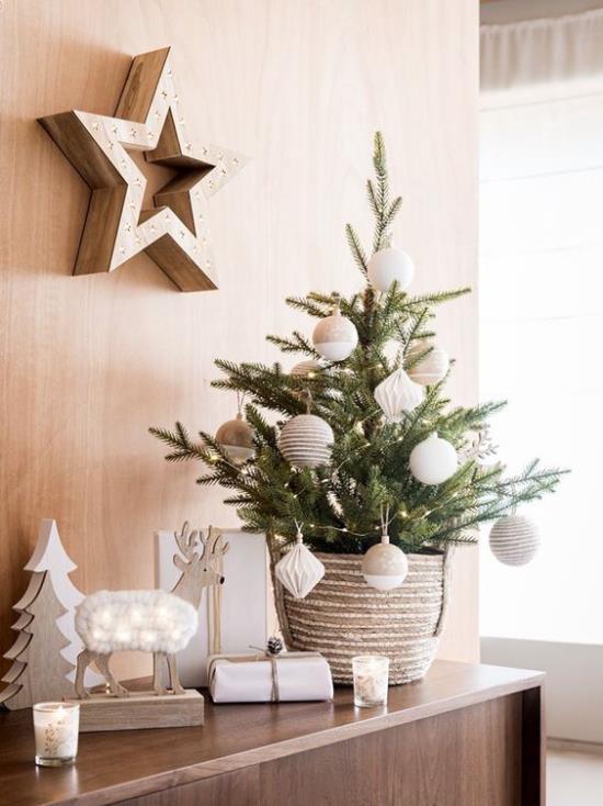 Μικρό χριστουγεννιάτικο δέντρο στολίζει καμαρωτή κομψή διακόσμηση στο αστέρι στον τοίχο