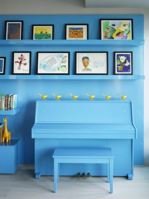 Γκαλερί τέχνης με κορνίζες στον τοίχο με μπλε έπιπλα
