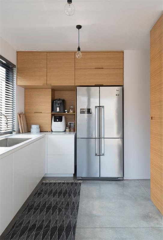 Οι μονάδες τοίχου L-κουζίνας από ανοιχτόχρωμο ξύλο μπορούν εύκολα να συνδυαστούν με γκρι ασημί ψυγείο