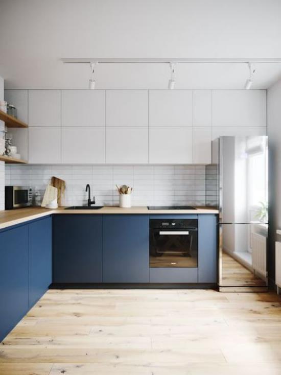 L-κουζίνα κομψός σχεδιασμός κουζίνας σε ντουλάπια με σκούρο μπλε χρώμα σε σχήμα L λευκά ντουλάπια τοίχου ξύλινο πάτωμα φωτιστικό οροφής