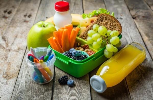 Τα παιδιά μεσημεριανό κουτί τρώνε υγιεινό χυμό φρούτων νηπιαγωγείου