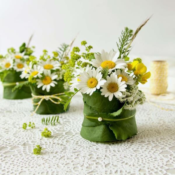 Λευκά λουλούδια μαργαρίτες σε ανθοδέσμες είναι η τέλεια διακόσμηση τραπεζιού για μια γιορτινή περίσταση