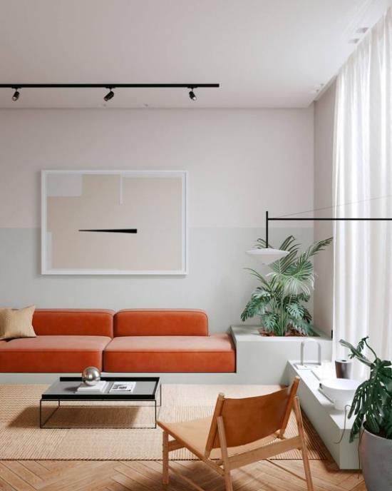 Ο πορτοκαλί καναπές φέρνει περισσότερο χρώμα στο εσωτερικό φωτεινό περιβάλλον, υπέροχα πράσινα φυτά εσωτερικού χώρου που τραβούν τα βλέμματα