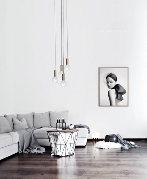 Μινιμαλισμός στο σαλόνι γωνιακός καναπές μικρά τραπέζια κεριά κρεμαστά φωτιστικά ζωγραφική τοίχου ηρεμία και απλότητα