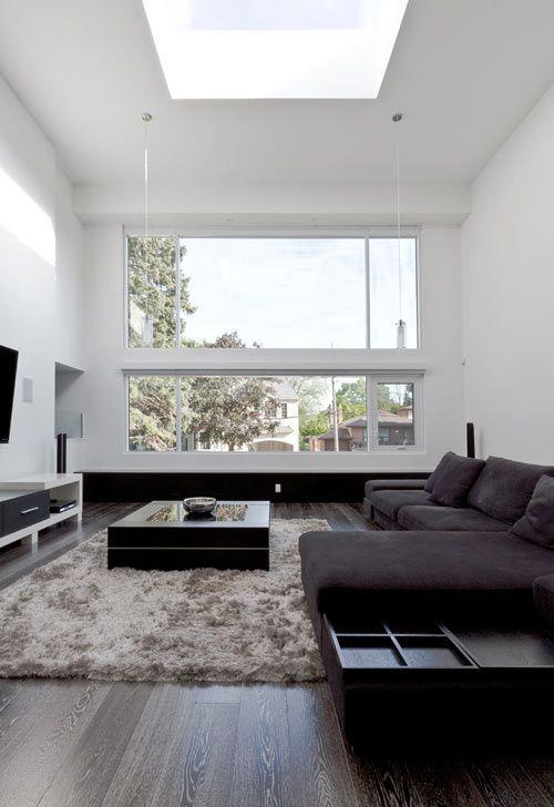 Μινιμαλισμός στο σαλόνι τέλεια σχεδίαση σκοτεινός γωνιακός καναπές χαλί τοίχος τηλεόρασης μεγάλο παράθυρο πολύ φυσικό φως