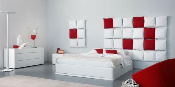Μινιμαλιστικό κόκκινο μαξιλάρι κρεβατοκάμαρας λευκό τοίχο άνετο