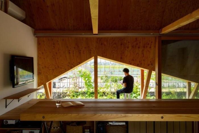 Μινιμαλιστικό σπίτι στην Ιαπωνία μεγάλα τριγωνικά παράθυρα με θέα στον ιαπωνικό κήπο και άλλα κτίρια