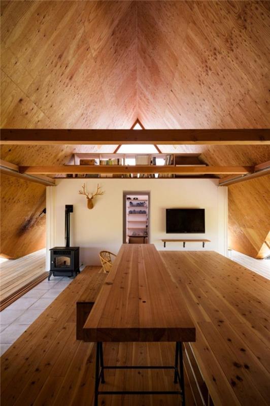 Μινιμαλιστικό σπίτι στην Ιαπωνία με τη μορφή σκηνής δύο επιπέδων στο σαλόνι χωρισμένο με βιβλιοθήκη από ξύλο