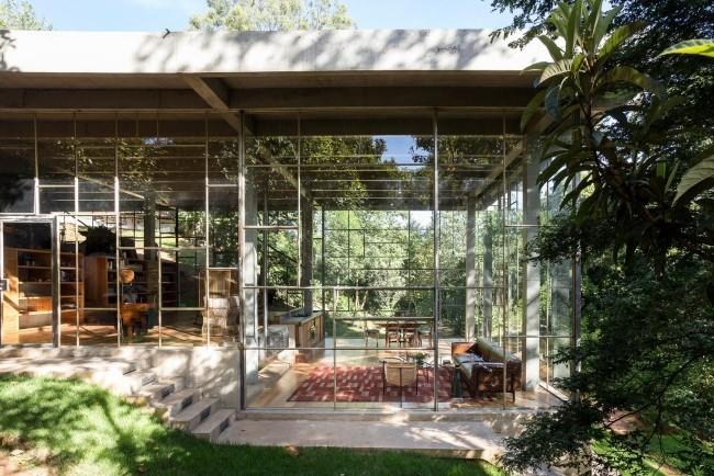 Το μοντέρνο γυάλινο και τσιμεντένιο σπίτι χτισμένο στο τροπικό δάσος είναι αρμονικά ενσωματωμένο στο περιβάλλον