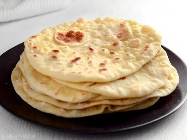 Bήνουμε ψωμί naan και το στοιβάζουμε στο πιάτο