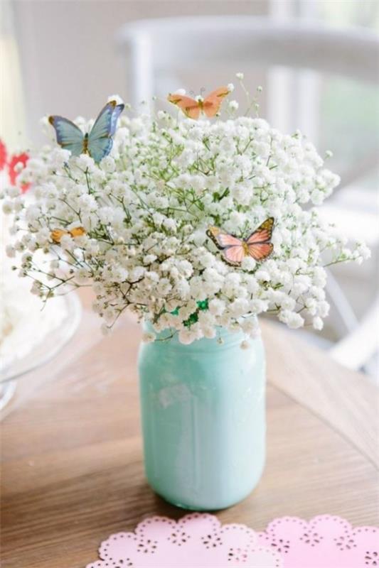 Πασχαλινή διακόσμηση σε παστέλ χρώματα λευκά λουλούδια από το λιβάδι στο ποτήρι ως πεταλούδα που τραβάει τα βλέμματα