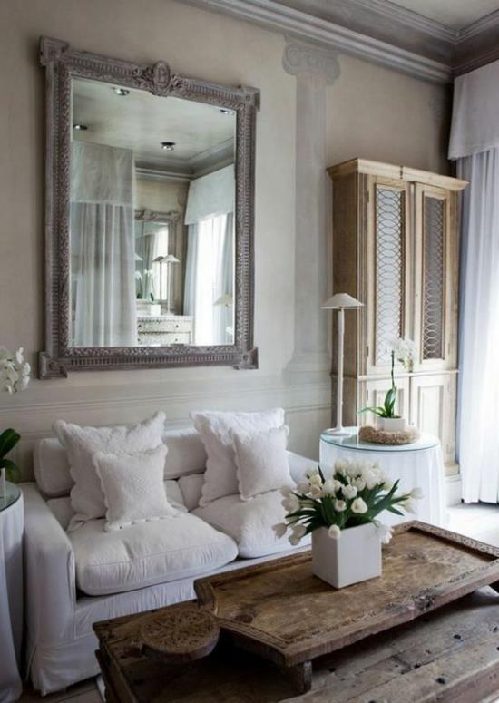 Στυλ Προβηγκίας άνετο σαλόνι ρομαντικό εσωτερικό σχέδιο άνετα έπιπλα λευκά καλύμματα μαξιλάρια ξύλινο τραπέζι λευκές τουλίπες τοίχου καθρέφτη