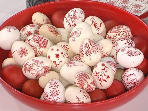 Κόκκινα πασχαλινά αυγά που ζωγραφίζουν μοτίβο διακοσμημένο λευκό
