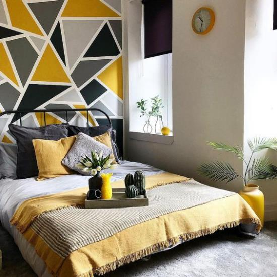 Ιδέες κρεβατοκάμαρας σε γκρι και κίτρινο τοίχο με έμφαση πίσω από τον ύπνο με μοτίβο γεωμετρικών μορφών