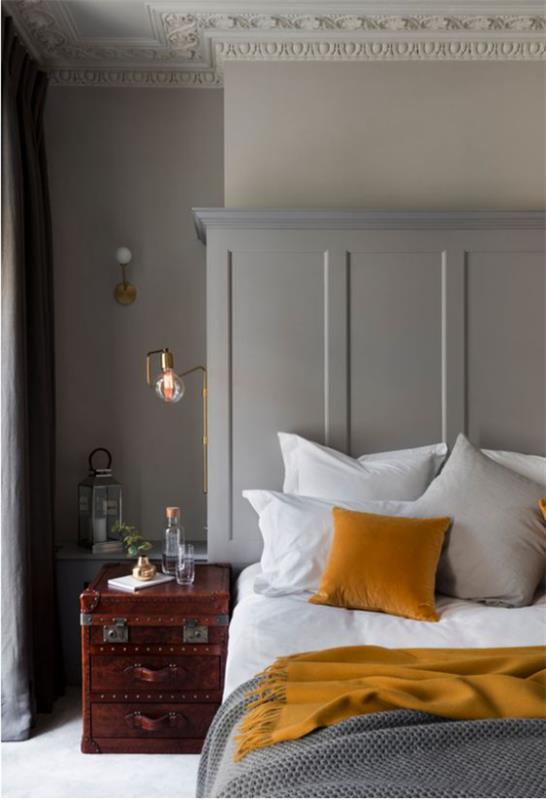 Ιδέες κρεβατοκάμαρας σε γκρι και κίτρινη απλή διακόσμηση δωματίου παλιά βαλίτσα ως κομοδίνο λευκά κλινοσκεπάσματα γκρι κουβέρτα κίτρινο μαξιλάρι