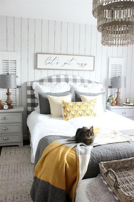 Ιδέες κρεβατοκάμαρας σε γκρι και κίτρινο δωμάτιο που καλεί οπτικά ισορροπημένη γάτα στο κρεβάτι