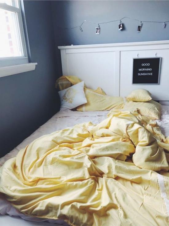 Ιδέες κρεβατοκάμαρας σε γκρι και κίτρινο άστρωμα κρεβάτι λευκά κλινοσκεπάσματα ανοιχτό κίτρινο σκούρο γκρι τοίχους παράθυρα