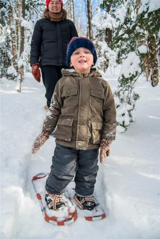 Χιονοπέδιλα παιδιά που κάνουν πεζοπορία στις χειμερινές διακοπές χιονιού