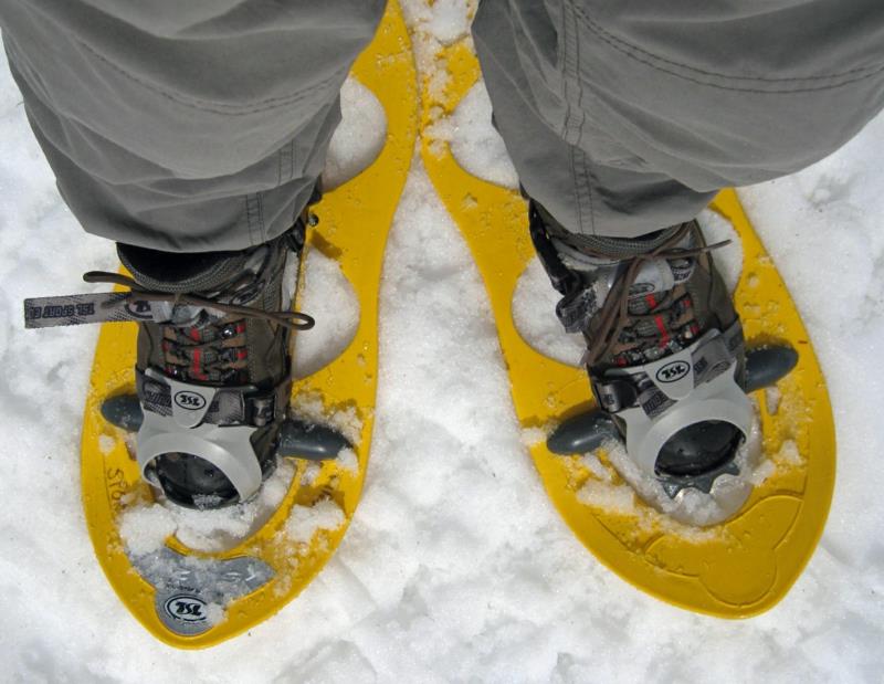 Κίτρινα χιονοπέδιλα που περπατούν στις χειμερινές διακοπές χιονιού