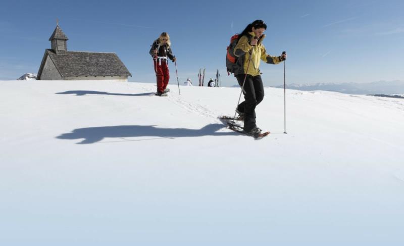 Χιονοπέδιλα που περπατούν στο χιόνι απολαμβάνοντας τις χειμερινές διακοπές