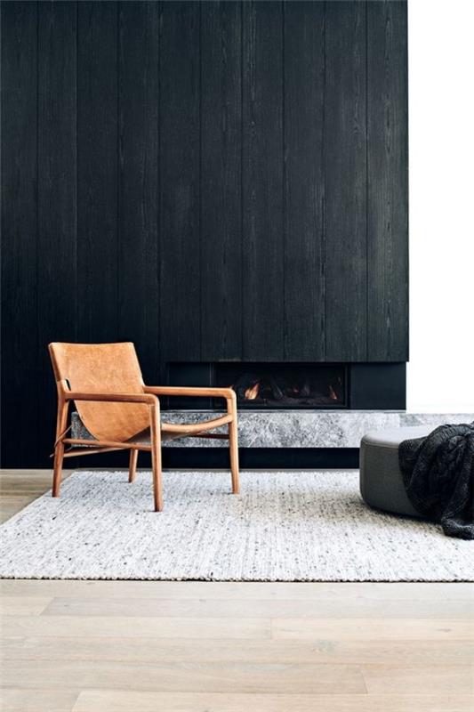 Μαύρος τοίχος σαλόνι τζάκι μια καρέκλα σε σκούρο φόντο γκρι σκαμπό χαλί