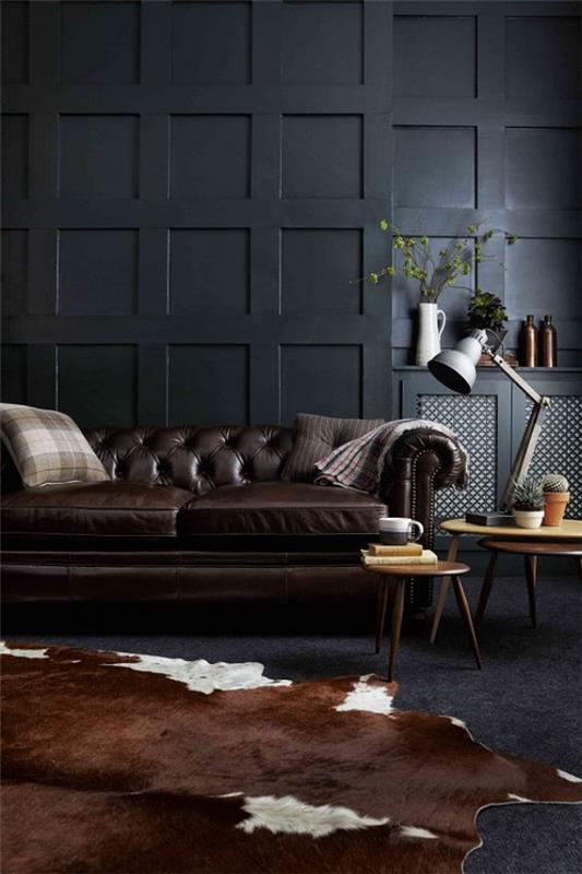 Μαύρος τοίχος στο σαλόνι καφέ δερμάτινος καναπές δερμάτινος καναπές χαλί μαξιλάρια δύο μικρά στρογγυλά τραπέζια από ελαφρύ ξύλο
