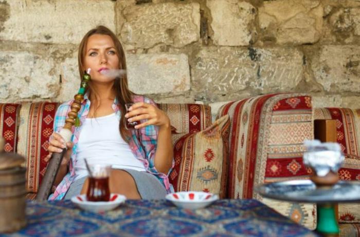 Κατάστημα Shisha κοντά σε περσικό χαλί ναργιλέ με γυναίκα