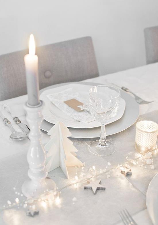 Γιορτάζοντας την παραμονή της Πρωτοχρονιάς στο σπίτι τραπέζι γκρι και άσπρα φώτα σταφυλιών που στήνουν λευκό κερί