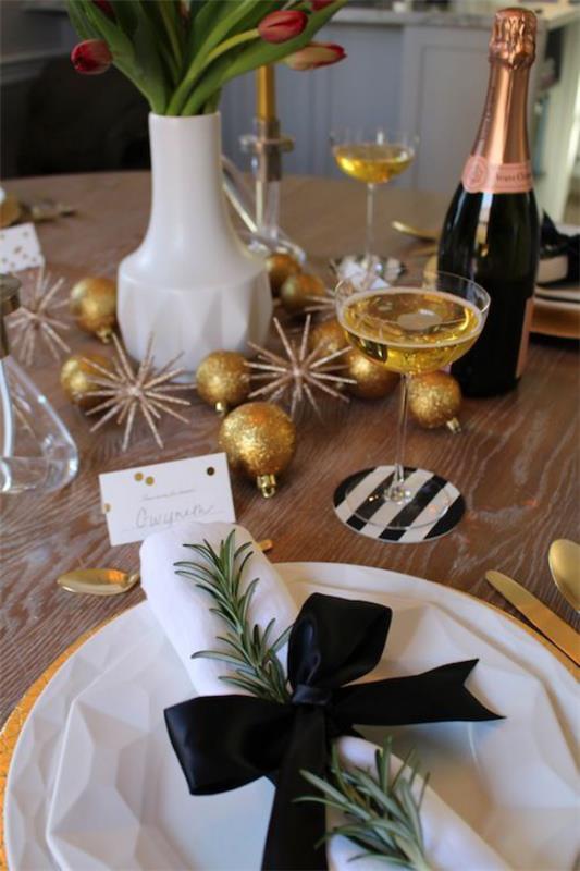 Γιορτάζοντας την Πρωτοχρονιά στο σπίτι λευκή χαρτοπετσέτα μαύρη κορδέλα πολλά χρυσά glitter βάζο μπουκαλιών σαμπάνιας με τουλίπες